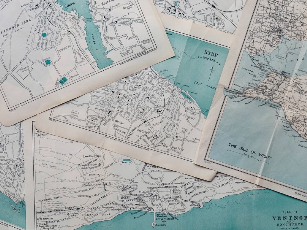 Mapas antiguos de la costa inglesa, extendidos sobre una mesa